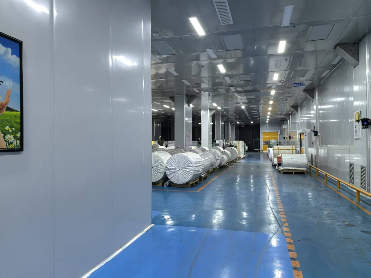 Clean production hall with epoxy flooring and palletized film rolls