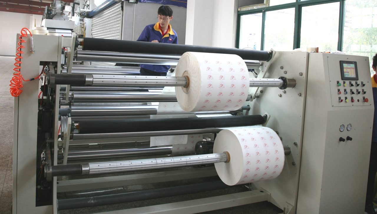 Operator running a slitting machine with patterned rolls